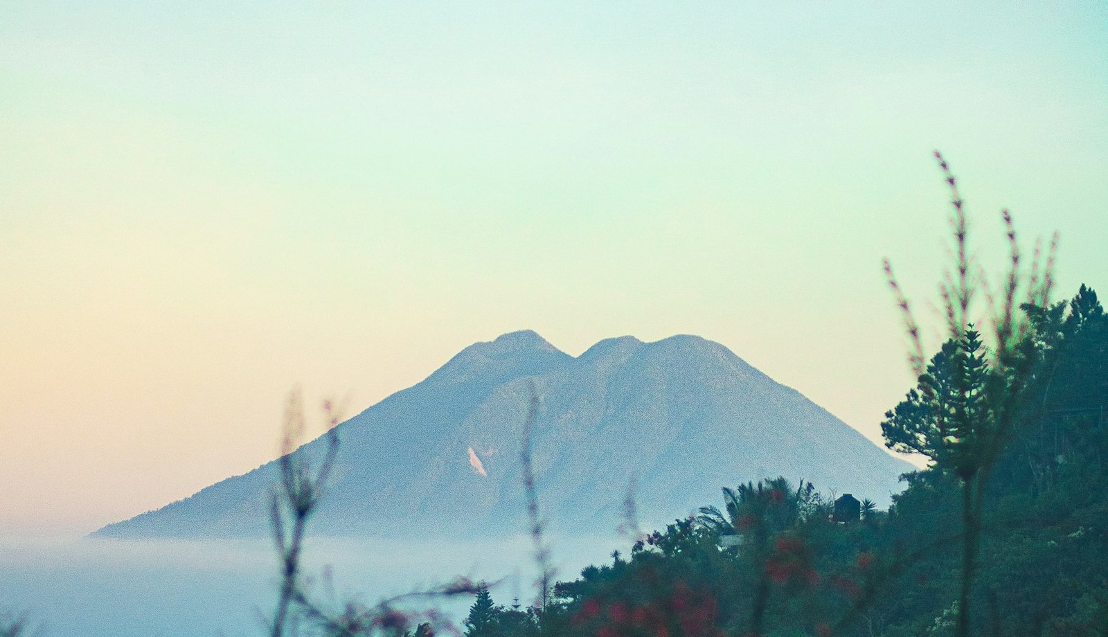 Volcanic peak at dawn with tropical foliage